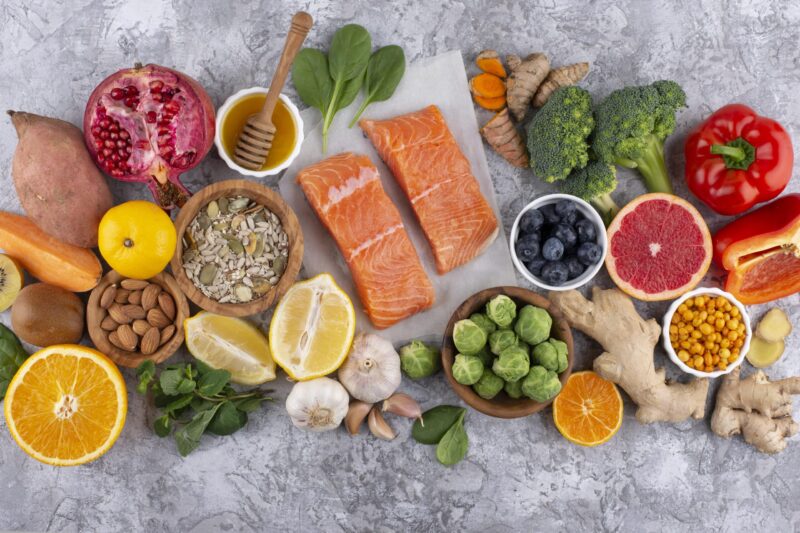 top view immunity boosting foods with vegetables fish scaled e1668543965837