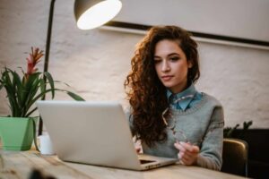 concentrated young beautiful businesswoman working laptop bright modern office scaled e1669130700195