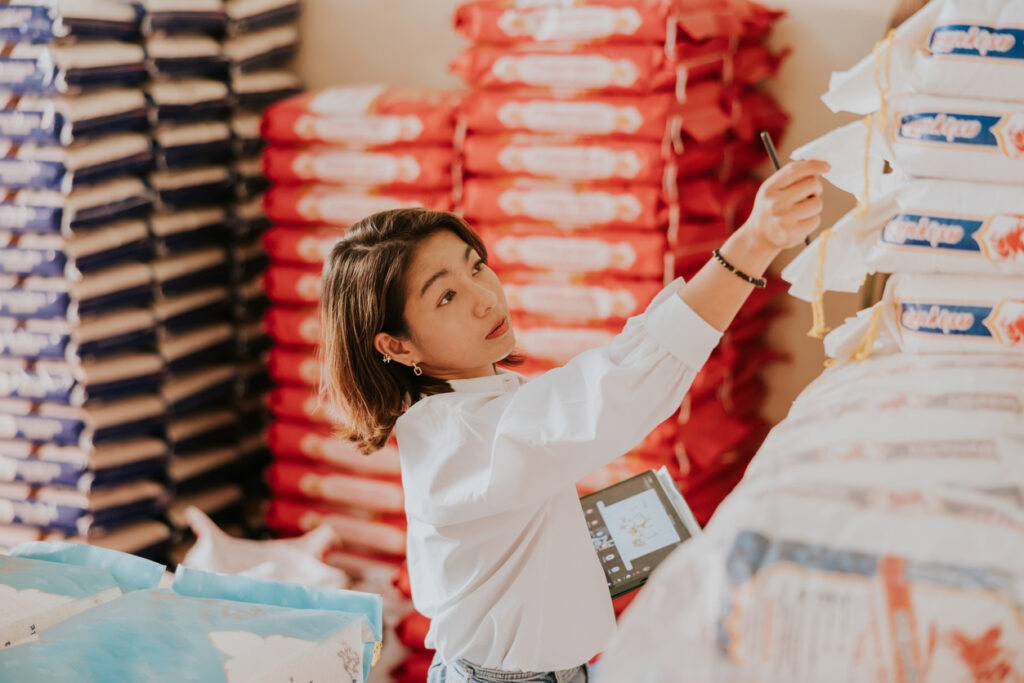 Checking quality of rice sack before delivery to customer As an FSVP importer, a woman carefully logs her rice imports for future evaluation to assure continued FSVP compliance.