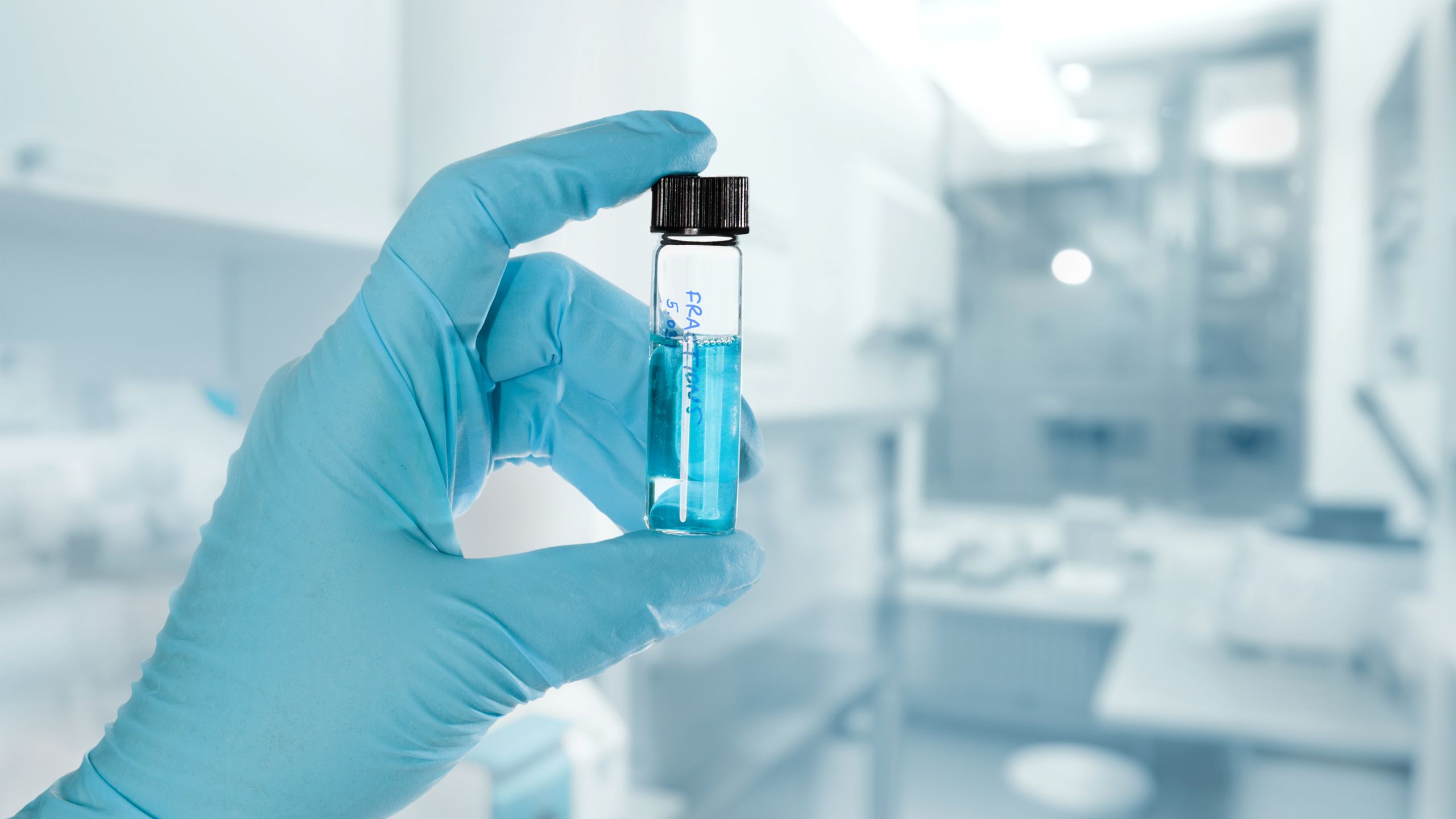 An Indian Drug is held in a gloved hand, the manufacturer awaiting FDA registration and Product listing.
