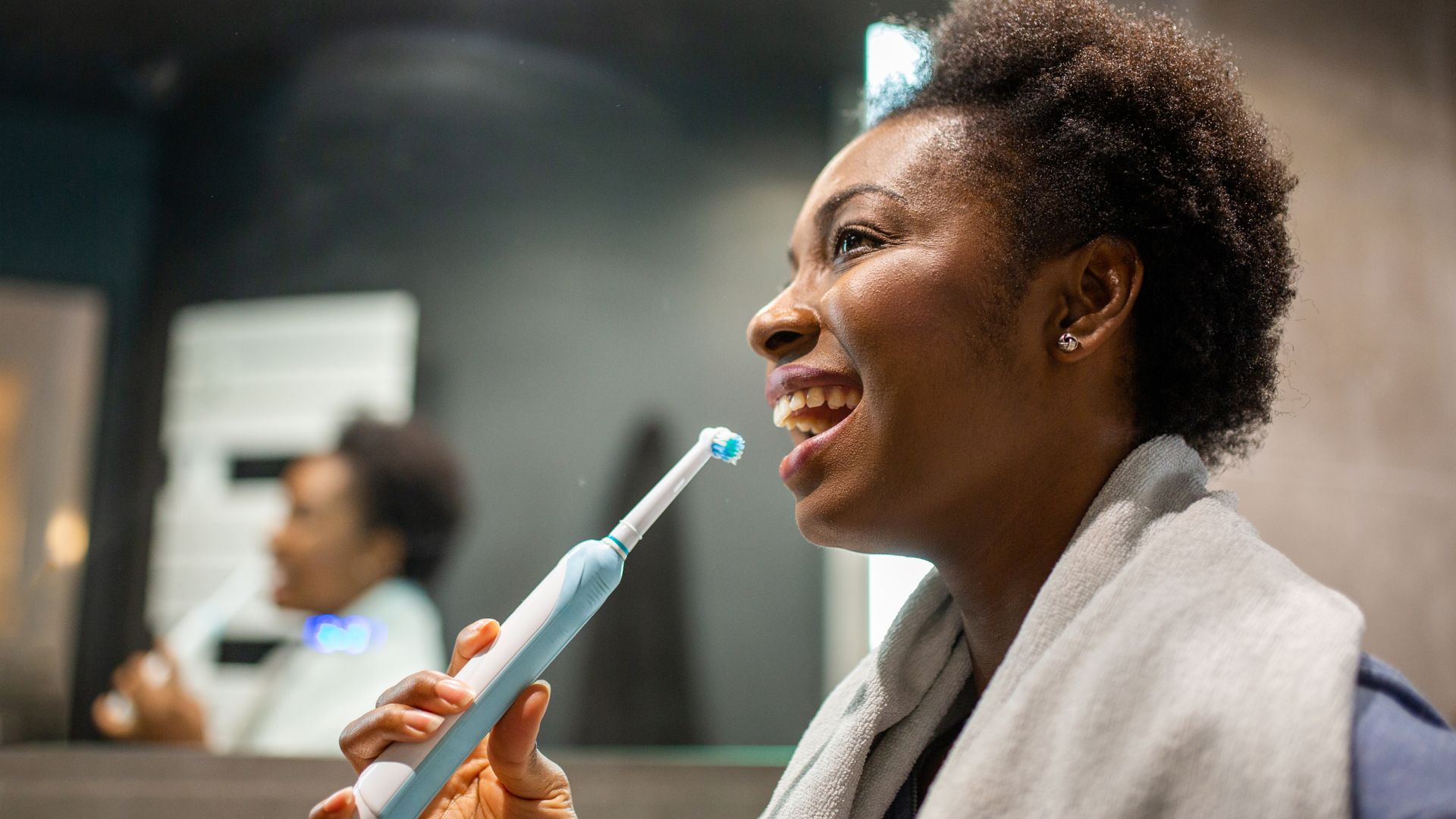 A woman uses one of the many electric toothbrushes on the market.