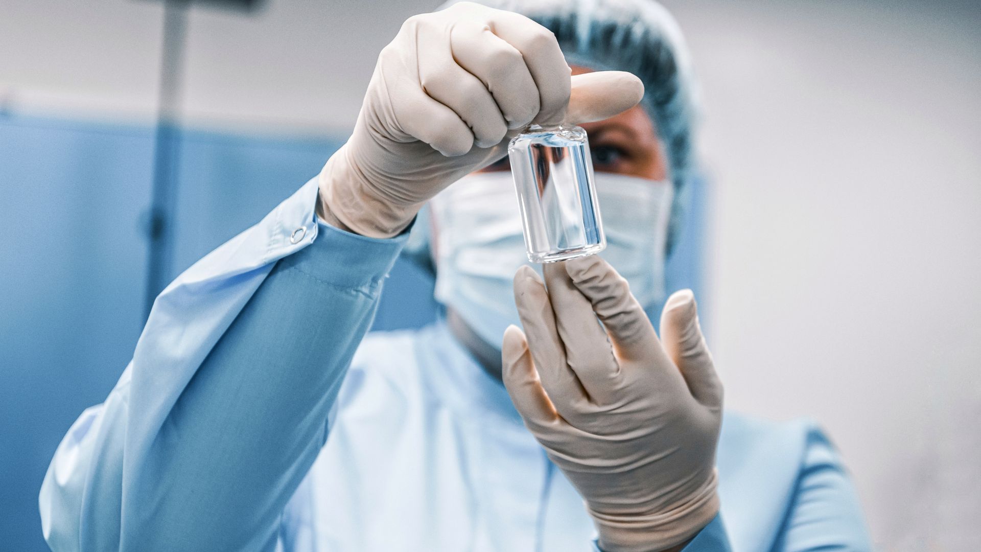 A medical professional holds up a vile of a compound approved after Drug Master File (DMF) Submissions.